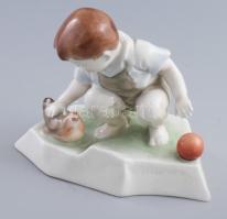 Zsolnay porcelán kisfiú tyúkocskával, kézzel festett, jelzett, (tervezte: Sinkó András), apró pattanással a csőrén 14×16 cm