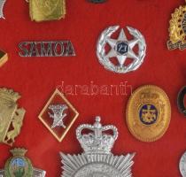 20 ország katonai és rendőri sapkajelvényei összesen 52 db, üvegezett vitrinben 70x40 cm