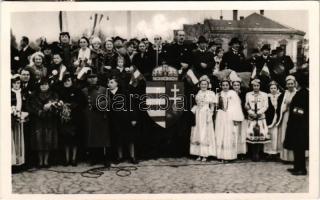 1938 Léva, Levice; Kossuth Lajos tér, bevonulás, a Honvédség fogadtatása, honleányok, magyar címer, a pódiumon Teleki Pál vallás- és közoktatásügy miniszter / square, entry of the Hungarian troops, compatriot women, coat of arms, welcoming the soldiers; Pál Teleki member of the Hungarian Government + 1938 Léva visszatért So. Stpl.