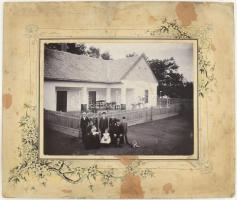 cca 1910 Családi csoportkép a ház előtt, keményhátú fotó Stríberny F. nagykátai műterméből, foltos, sérült kartonnal, 17x22 cm.