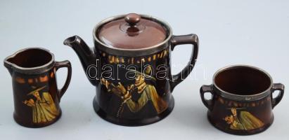 cca 1920, Royal Doulton Kingsware háromrészes szervírozó szett, a Hamelni patkányfogó alakjával díszítve, ezüst (Ag) peremezéssel, pótol fedővel, kanna csőrén lepattanással. Jelzett, peremezés jelzett, m: 15 cm alatt. /// Circa 1920, Royal Doulton Kingsware Three-Piece Serving Set, decorated with the Hamelin Piper figure, with silver (Ag) rim. Replacement lid, minor chipping at the spout of the jug. Marked, rim marking present. Height: under 15 cm