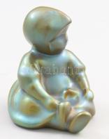 Zsolnay kisplasztika - üldögélő kendős kislány. Terv.: Sinkó András, eozin mázakkal festett öntött finomfajansz, savmaratott felületű. Jelzett, hibátlan , m: 7,5 cm