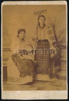 cca 1880-1900 Erdélyi(?) népviseletes hölgyek, egyikük kezében gereblyével és kerámia kancsóval, keményhátú fotó, jelzés nélkül, alja vágott, 15,5x10 cm