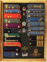 cca 1949-1959 Katonai, rendőr összeállítás: Magyar Néphadsereg váll-lapok, felvarrók, rendőr sapkajelvény, stb., összesen 27 db, keretben, külső méret: 48x37,5 cm