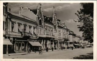 1940 Szatmárnémeti, Satu Mare; Horthy Miklós tér, Fischer és Fried, Vágó Imre és Sámuel Ignác üzlete, Erdélyi Bank, férfi kerékpáron. Huszár Aladár kiadása / square, shops, bank, bicycle