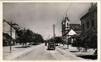 1943 Galánta, Fő utca, templom, kerékpárok, autó, dohányáruda. Magyar Tanítók Szövetkezeti Könyvesboltja kiadása / main street, church, bicycles, automobile, tobacco shop