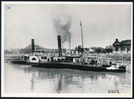 S.M.D. Herkules a Dunai Flottila vontató hajójának használt hajó fényképe későbbi nagyítás 18x14 cm  Modern reproduction (horizontal, 17.8 cm x 13.1 cm) from an original negative. Portside view of Herkules docked at the landing facilities of an industrial town. The photograph comes perhaps from the DDSG?s files