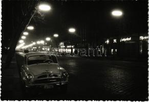 Budapest VII. A kivilágított Rákóczi út este, üzletek, gyógyszertár, régi Skoda autó. Foto Czeizing Lajos. Képzőművészeti Alap Kiadóvállalat