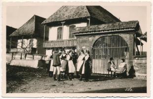 Kecsetkisfalud, Satu Mic; Székely kapu előtt népviseletbe öltözött helyi lakosok. Kováts István felvétele / local people in folk costumes in front of the traditional Szekler wooden carved gate. photo (EK)