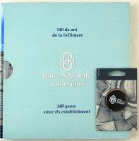 Románia 2020. "A Román Nemzeti Bank 140 évvel alapítása után" (filatéliai emlékalbum kartontokban, benne többek között emléklap, bélyegek és bélyegzett borítékok) + "Banca Nationala a Romaniei" hűtőmágnes. Használt, de újszerű állapotban, enyhe ázás nyom a tokon Romania 2020. "140 de ani de la infiintare - Banca Nationala a Romaniei - 140 years since its establishment" (philatelic souvenir album in a cardboard case, containing a commemorative card, stamps, and stamped envelopes) + "Banca Nationala a Romaniei" fridge magnet. Used, but in good condition, slight moisture on the case