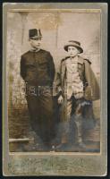 1915 Karánsebes, két fiú műtermi portréja, egyik katonai egyenruhában, másik felnőtt katonai zubbonyban, keményhátú fotó hátoldalon feliratozva, szecessziós hátlappal, foltos, 10,5×6,5 cm