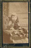 cca 1880 Kislány fotelban, keményhátú fotó Wittmann komáromi műterméből, felületi sérülésekkel, 10,5×6,5 cm