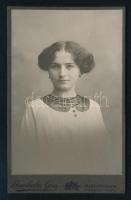 cca 1910 Női portré, keményhátú fotó Brunhuber Géza budapesti műterméből, átadó tasakkal, 10,5×6,5 cm