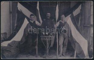 cca 1915 Katona és két fiatalember italokkal, zászlókkal, fotólap, jelzés nélkül, 9x14 cm
