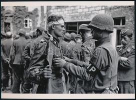 cca 1944 Robert Capa (1913-1954) (eredeti neve Friedmann Endre) magyar - francia fotóriporter felvétele (fogságba esett német katonát motoz egy amerikai katona), 1 db modern nagyítás, jelzés nélkül, Fotó újság archívumából, 15x21 cm