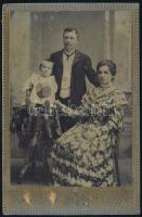 cca 1900 Fiatal pár fotója gyermekével, keményhátú fotó Kohlmann Sándor ungvári műterméből, a felületén sérülésekkel, foltokkal, 16x10 cm.