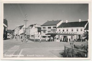 Gyergyószentmiklós, Gheorgheni; Kossuth Lajos tér, idegenforgalmi iroda, Páll Sándor vendéglője, üzletek / square, tourist office, restaurant, shops (vágott / cut)