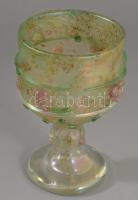 Smetana Ágnes (1961-) Kehely plasztikus virág díszítéssel. Anyagában színezett, üvegszál ráillesztésekkel díszített, kézzel formázott hutaüveg. Jelzés nélkül, m: 19 cm  ///  "Smetana Ágnes üvegművész alkotásainak kiapadhatatlan inspiráló forrása a természet változatossága és gazdagsága. Tartózkodik a statikus és szabályos formáktól, munkáit organikus formák, melengető, üde színek jellemzik. A formába fúvott, hutakész üvegvázák felületét: pipacsok, magnóliák, liliomok, indák, levelek, bogyók plasztikusan kialakított kompozíciói díszítik, amelyek felidéznek számunkra virágos rétet és mezőt, a természet adta értékeket és érzéseket, mindazt a gyönyörűséget, mely az ember számára létszükség és mégis olykor oly távol kerülünk tőle. Alkotásait még izzó állapotban, különböző szemcsefinomságú színes üvegzúzalékkal (grézlivel) színezi, tehát tapasztalataira hagyatkozik, hiszen a vörösen izzó anyag csak lehűlése után mutatja meg igazi színeit. Az edények florális díszítményeit melegen feltett üvegszálakból, illetve üvegcseppekből alakította ki a művész. A vázák felülete finoman irizál."