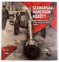 Szabadságharcosok között. John Sadovy fényképei az 1956-os magyar forradalom napjaiból. Szerk.: Kiss Réka, L. Simon László. [Bp.], 2023, Magyar Nemzeti Múzeum - Nemzeti Emlékezett Bizottsága, 151 p. Gazdag képanyaggal illusztrált. " John Sadovy (1925?2010), a Life című amerikai képes hetilap számára tudósító, cseh származású fotóriporter 1956. október 29. és november 1. között volt szemtanúja és krónikása az október 23-án kitört magyarországi forradalom eseményeinek. A Magyar Nemzeti Múzeum és a Nemzeti Emlékezet Bizottsága, együttműködésben a fotós két lányával, Liza Jane Sadovyval és Yvonne Sadovy de Mitchesonnal, mutat be válogatást John Sadovy 1956-ban készített felvételeiből. A fotóriporter világhírűvé vált képei mellett több olyan, Magyarországon eddig még nem látott felvételt is bemutatunk, amelyek bepillantást engednek a szabadságharcosok tűzszünet alatti életébe, és egy ausztriai menekülttáborban várakozó magyarok világába." moly.hu Kiadói papírkötés.