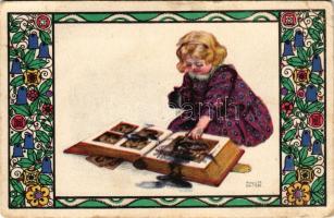 1917 Child with ink and photo album. B.K.W.I. 587-4. s: August Patek (EB)