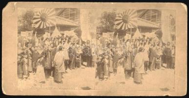 cca 1900 Japán, hazaérkező katonákat fogadó, ünneplő tömeg zászlókkal, keményhátú sztereofotó, a hátoldalon Hatschek Emil bélyegzőjével, kissé sérült karton, 8,5x17 cm