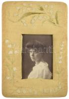 cca 1900-1910 Fiatal hölgy portréja, keményhátú fotó, hímzett virágos díszítésű, vászonborítású képkeretben, látható: 13,5x9,5 cm, külső méret: 29x20 cm