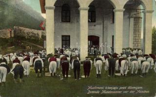 Praying muslims in front of a Mosque