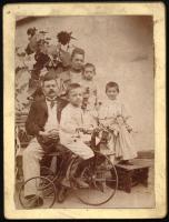 cca 1910 Családi portré, rajta triciklin ülő kisfiú, keményhátú fotó, 12x9 cm