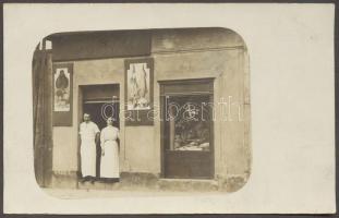 cca 1930 Húsfüstölde tulajdonosaival, fotólap /  Meet smoking shop with owners, photo card