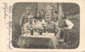 Soldiers, women near the table, photo