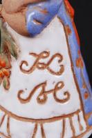 Kovács Margit (1902-1977): Kislány virággal. Festett kerámia, jelzett, copfján apró lepattanás / Gir...