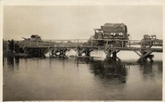 Tractors crossing a river on a makeshift bridge