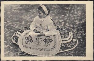 cca 1960 Kalocsavidéki gyermek ünneplőben, hátulján magyarul és németül feliratozva, kisebb szakadás...